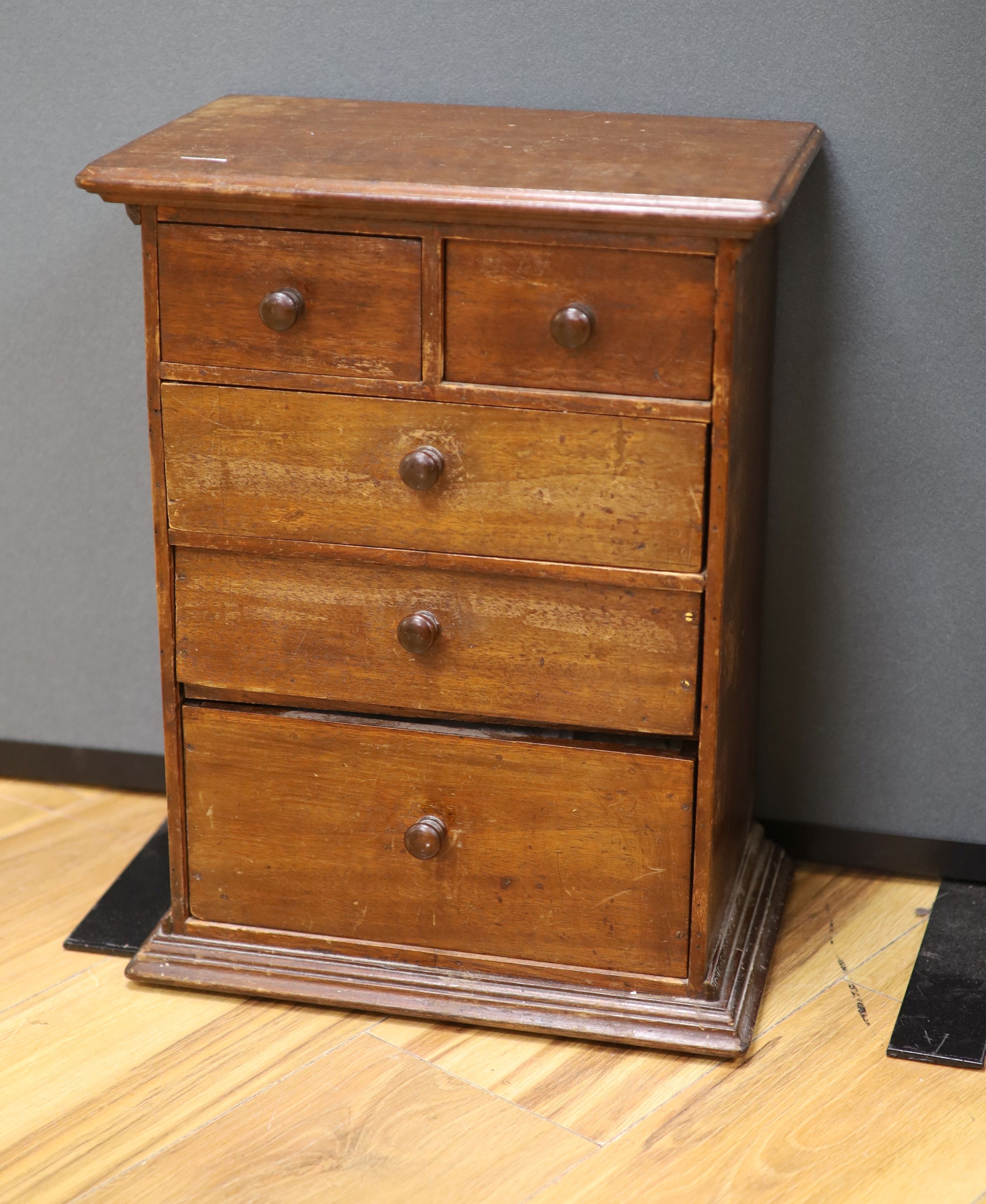 An early 20th century miniature chest and contents